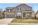 Charming two-story home with gray siding, stone accents, and a well-maintained lawn at 12185 S Grass River Trl, Parker, CO 80134