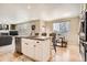 Kitchen island with sink and chairs open to the living and dining areas, ideal for entertaining at 12185 S Grass River Trl, Parker, CO 80134