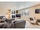 Bright living room with a fireplace, plush seating, and natural light from the large window at 12185 S Grass River Trl, Parker, CO 80134