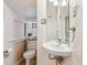 Compact bathroom with a pedestal sink, a toilet, textured walls, and a small window for natural light at 434 N Washington St, Denver, CO 80203