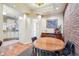 Inviting dining space with a brick wall, a wooden table set, and hardwood floors, leading to the kitchen at 434 N Washington St, Denver, CO 80203