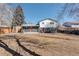 Spacious backyard with a red door, a patio, and an outbuilding near the wooden fence at 8229 Marshall Ct, Arvada, CO 80003