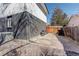 Image of a property's backyard with partial concrete and rock groundcover, and a modern black brick exterior at 8229 Marshall Ct, Arvada, CO 80003