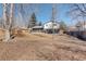 Large grassy backyard with mature trees and a wood fence creating a private outdoor space at 8229 Marshall Ct, Arvada, CO 80003