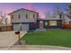 Charming two-story home with a well-manicured lawn and a brick exterior at dusk at 8229 Marshall Ct, Arvada, CO 80003