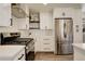 Well-equipped kitchen featuring stainless steel appliances, white cabinets, and a stylish backsplash at 8229 Marshall Ct, Arvada, CO 80003