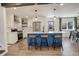Modern kitchen featuring a blue island with barstool seating, white cabinetry, and stainless steel appliances at 8229 Marshall Ct, Arvada, CO 80003