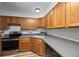 Kitchen view with modern appliances, gray countertops, and wood cabinetry at 871 S Joplin Cir, Aurora, CO 80017