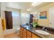 Bathroom featuring dual sinks, and wood cabinets with a dark countertop at 21395 E Greenwood Pl, Aurora, CO 80013