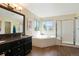 Bright bathroom featuring a tub, a shower and a dark wood vanity at 21395 E Greenwood Pl, Aurora, CO 80013