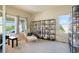 Bright, carpeted living room featuring large windows and a cozy reading area with a bookshelf at 21395 E Greenwood Pl, Aurora, CO 80013