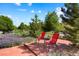 A red brick patio includes outdoor seating with a view of lush landscaping at 21395 E Greenwood Pl, Aurora, CO 80013