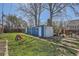 Backyard with blue outbuilding, slide, lush grass, and mature trees at 2252 S Lafayette St, Denver, CO 80210