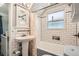 Bathroom featuring subway tile, pedestal sink, tub, and updated fixtures at 2252 S Lafayette St, Denver, CO 80210
