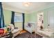 Bright Bedroom featuring a crib, a cozy chair, and an en suite bathroom at 2252 S Lafayette St, Denver, CO 80210