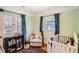 Bright Bedroom featuring two windows, a crib, and a cozy chair at 2252 S Lafayette St, Denver, CO 80210