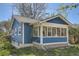 A charming side view of the home showcasing its blue siding and bright white sunroom at 2252 S Lafayette St, Denver, CO 80210