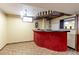 Basement bar area complete with red accents and unique ceiling design at 9202 W Virginia Pl, Lakewood, CO 80226