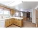 Bright kitchen with wood cabinetry, and laminate flooring open to a dining and living area with a fireplace at 9202 W Virginia Pl, Lakewood, CO 80226