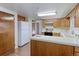 Kitchen with white tile countertops, white appliances, wood cabinetry, and laminate flooring at 9202 W Virginia Pl, Lakewood, CO 80226