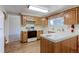 Traditional-style kitchen with wooden cabinets, laminate wood flooring, and white appliances at 9202 W Virginia Pl, Lakewood, CO 80226