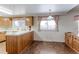 Kitchen with wood cabinetry, laminate flooring, and a window over the sink providing natural light at 9202 W Virginia Pl, Lakewood, CO 80226