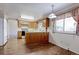 Kitchen with wood cabinets and laminate floor, leading into a carpeted area at 9202 W Virginia Pl, Lakewood, CO 80226