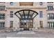 Grand building entrance featuring lion statues, covered glass entry, stone facade, and wrought iron balcony railing at 1827 N Grant St # 1104, Denver, CO 80203