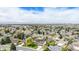 Expansive aerial view of a neighborhood featuring tree-lined streets and mountain views on a sunny day at 92 Helena Cir, Littleton, CO 80124