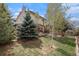 Landscaped backyard features green lawn, mature trees and access to wooden deck at 92 Helena Cir, Littleton, CO 80124