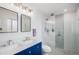 Modern bathroom featuring dual sinks, decorative tile, and a glass enclosed shower at 92 Helena Cir, Littleton, CO 80124