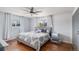 Well-lit bedroom featuring hardwood floors, a ceiling fan, and two windows at 92 Helena Cir, Littleton, CO 80124