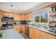 Bright kitchen featuring wood cabinetry, modern appliances, and a window with a view at 92 Helena Cir, Littleton, CO 80124