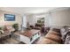 Comfortable living room with a large leather sofa, decorative coffee table, and ample natural light at 92 Helena Cir, Littleton, CO 80124