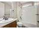 Bathroom features a shower over bath with white tile, a light wood vanity, and neutral wall paint at 19782 W 59Th Ave, Golden, CO 80403
