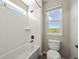 Bathroom featuring a shower over bath with white tile, a toilet and a view of the hillside at 19782 W 59Th Ave, Golden, CO 80403