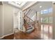 Open staircase with carpeted steps, wood banister, and wrought iron spindles at 19782 W 59Th Ave, Golden, CO 80403