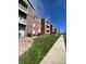 Exterior view of a multi-story brick apartment building with balconies and sidewalks at 2705 S Danube Way # 304, Aurora, CO 80013