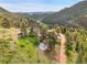 Birds eye view of mountain home surrounded by lush valley and winding road at 6094 Pyrenees Trl, Golden, CO 80403