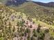 A serene aerial view showcasing a home nestled amongst the trees on a mountain landscape at 6094 Pyrenees Trl, Golden, CO 80403