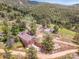 Panoramic aerial view showcasing the home's location nestled amongst mature trees and mountain views at 6094 Pyrenees Trl, Golden, CO 80403