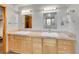 Bathroom vanity featuring double sinks with ample cabinet space, framed mirrors, and great lighting at 6094 Pyrenees Trl, Golden, CO 80403