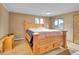A well-lit bedroom featuring a large wooden bed frame with built-in drawers and light hardwood flooring at 6094 Pyrenees Trl, Golden, CO 80403