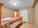 This bedroom features hardwood floors and a cozy bed with red knit blanket and access to the closet at 6094 Pyrenees Trl, Golden, CO 80403