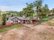 Stunning multi-level home nestled among mature trees with mountain views and a wraparound brick-lined patio at 6094 Pyrenees Trl, Golden, CO 80403
