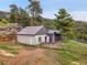 Exterior view of a house featuring sheds, a fenced yard, and scenic surroundings at 6094 Pyrenees Trl, Golden, CO 80403
