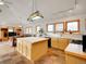 Bright, open kitchen with large center island, light wood cabinetry, and stainless steel appliances at 6094 Pyrenees Trl, Golden, CO 80403