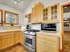 Well-equipped kitchen with stainless steel appliances, bright wood cabinetry, and hardwood floors at 6094 Pyrenees Trl, Golden, CO 80403