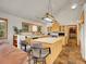 Open kitchen with central island, wood cabinetry, and hardwood floors with views to the living room at 6094 Pyrenees Trl, Golden, CO 80403