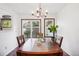 Dining room features a wood table, chandelier, and sliding glass doors to a patio at 2103 Ranch Dr, Westminster, CO 80234